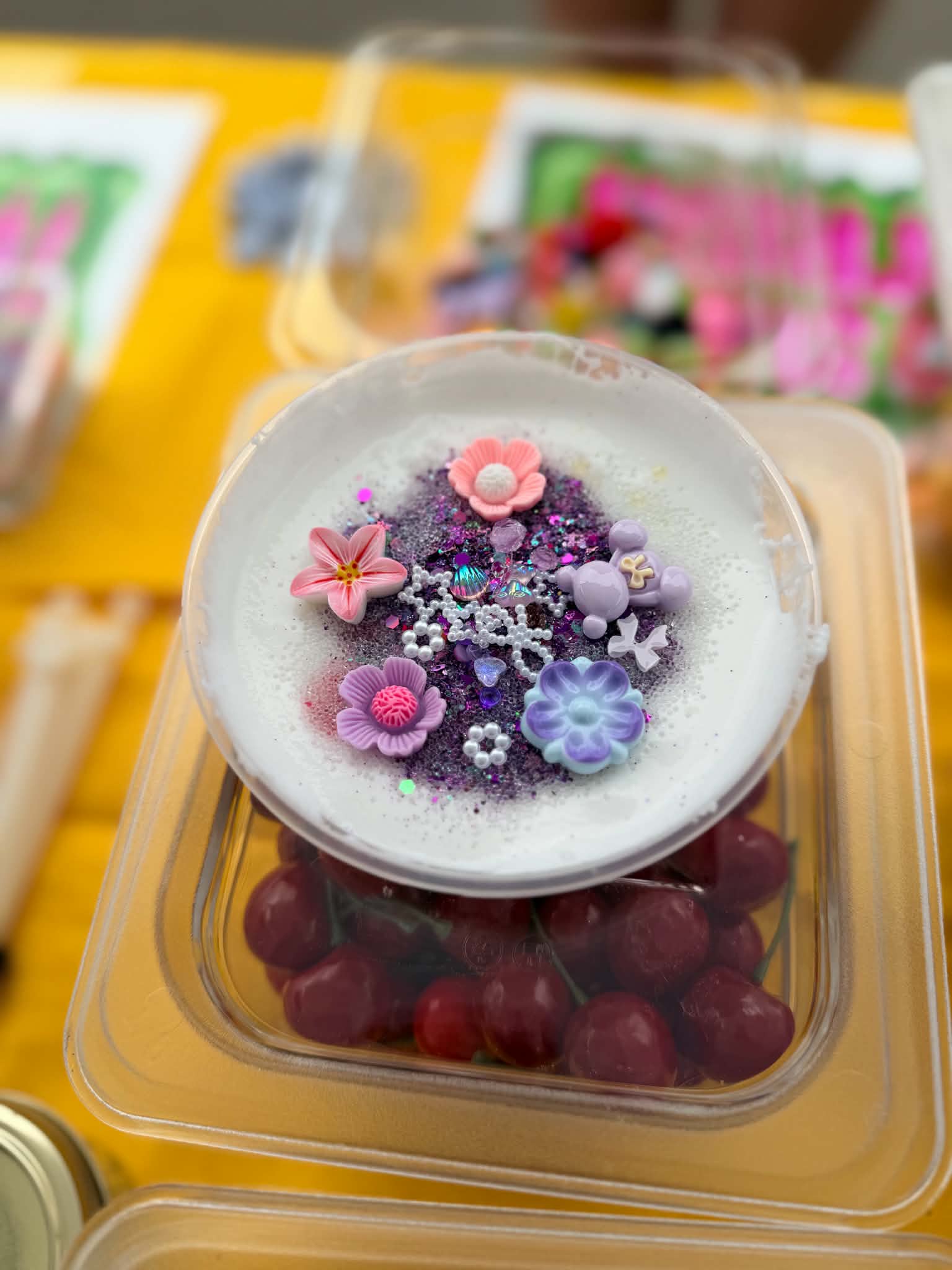 Cloud slime decorated with pink and purple flowers, charms, and sparkle